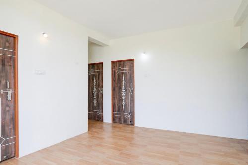 a room with white walls and wooden doors at Hotel O Sky Villa in Nagpur