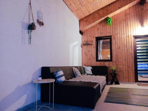 a living room with a black couch and a table at Popa Cabana in Sibiu