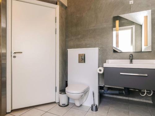 a bathroom with a toilet and a sink and a mirror at 5 star holiday home in Hadsund in Hadsund