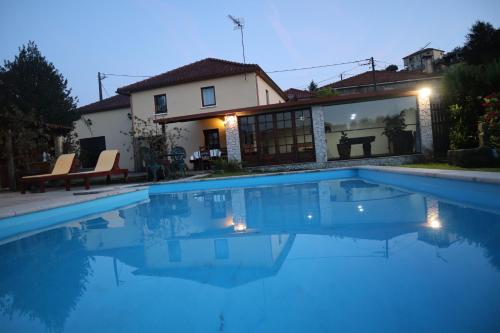 a swimming pool in front of a house at Casa de Penim in Paredes de Coura