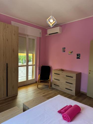 a bedroom with pink walls and a bed and a dresser at Belvedere MareMonti in Belvedere Ostrense