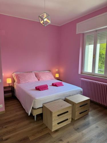 a bedroom with a large bed with pink walls at Belvedere MareMonti in Belvedere Ostrense