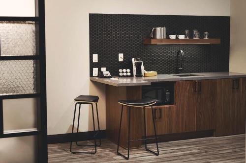 a kitchen with a counter with stools and a sink at Hotel Vandivort in Springfield