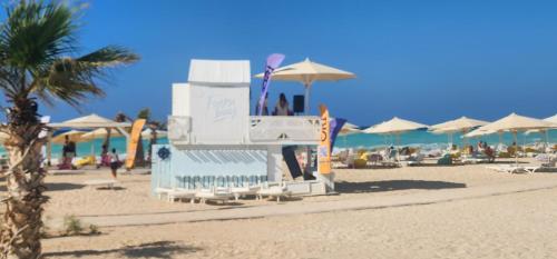 a beach with chairs and umbrellas on the beach at Fouka Bay North Coast 2BRs Modern Style Serviced Apartment with Open Pool & Sea View in Marsa Matruh