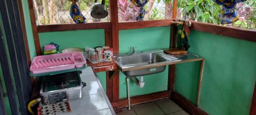 a small kitchen with a sink and a refrigerator at La Chonta de Corcovado in Puerto Jiménez