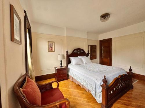 a bedroom with a large bed and a chair at PLG House in Brooklyn