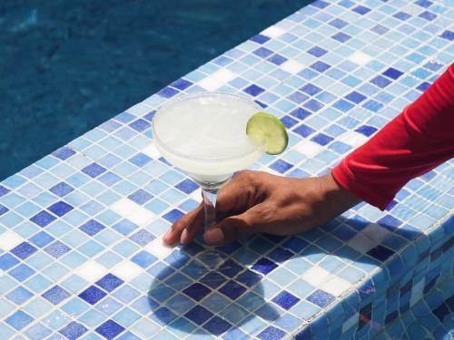 a person holding a drink with a lime on a table at Hotel La Riviera in Santa Marta