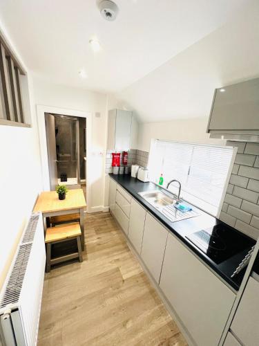 a kitchen with a sink and a wooden table at Yastayzzz at Studio 4 Bransford Rd in Worcester