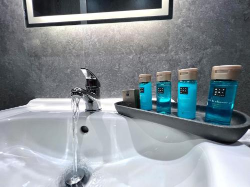 a bathroom sink with three bottles of blue liquid at Yastayzzz at Studio 4 Bransford Rd in Worcester