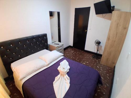 a bedroom with a purple bed with a headboard at Hostal las vegas Malaga in Estación El Salto