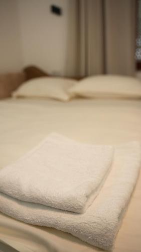 a stack of white towels on a bed at Apartments Kayaville in Sjenica