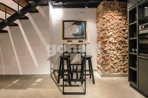 a bar with stools in a room with a brick wall at Inspiring Loft In The Center Of Ciudad Del Este in Ciudad del Este