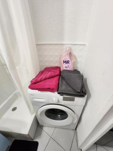 a white toilet in a bathroom with pink towels at Studio Antigone centre ville in Montpellier