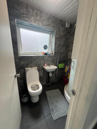 Un baño con inodoro, lavabo y ventana. en ROOM IN HARROW ON THE Hill, en Harrow