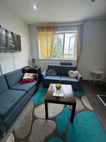 Una sala de estar con un sofá azul y una mesa. en ROOM IN HARROW ON THE Hill, en Harrow
