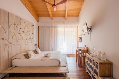 a bedroom with a large bed and a window at TEIMA, Alentejo SW in São Teotónio