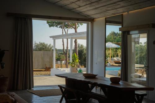 a dining room with a table and a view of a patio at Casa Thala - Conceptual 3-Suite Villa & Hot Pool in Alcácer do Sal