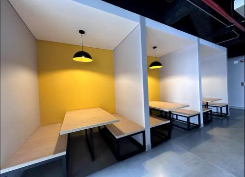 a row of tables in a room with yellow walls at Apartamento Cama Queen in Bogotá