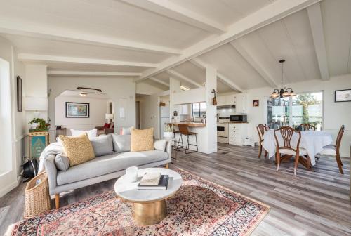 a living room with a couch and a table at The Pink House - Dungeness Waterfront Home in Sequim