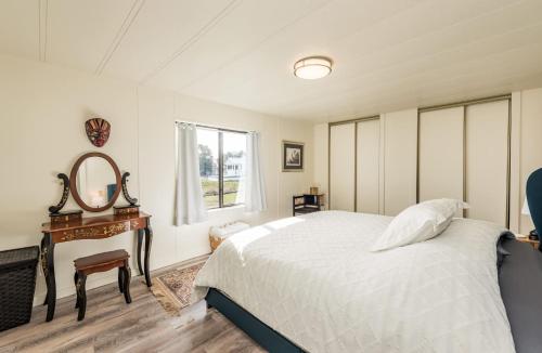 a bedroom with a bed and a mirror and a table at The Pink House - Dungeness Waterfront Home in Sequim
