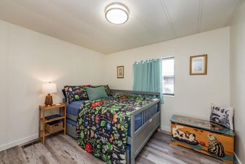 a small bedroom with a bed and a window at The Pink House - Dungeness Waterfront Home in Sequim