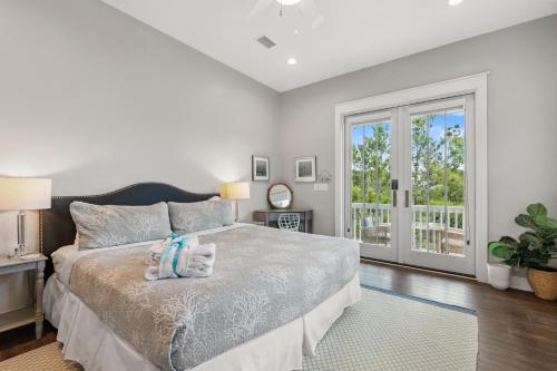 a bedroom with a bed and a large window at Aquamarine! Sleeps 12! Close to Community Pool! Private Beach Access! in Blue Mountain Beach