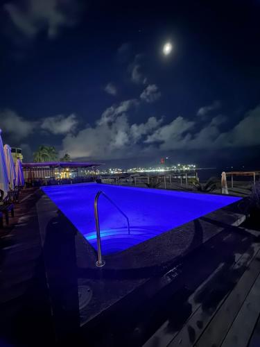a swimming pool with blue lighting at night at La Posada Hotel Boutique in Manzanillo