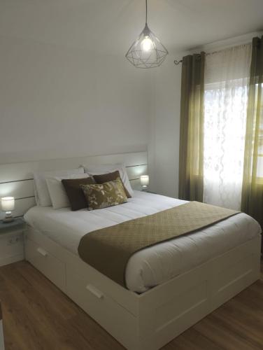 a bedroom with a large white bed with two lamps at Green Passion in Ponta Delgada