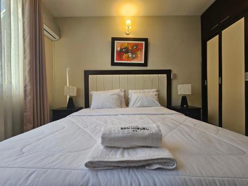 a bedroom with a bed with towels on it at Hotel San Miguel in Piura