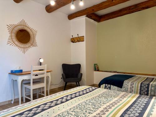 a bedroom with two beds and a desk and a chair at Location au cœur du Devès, proche Puy-en-Velay et chemin de St-Jacques - FR-1-582-447 in Bains