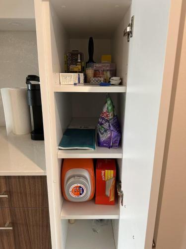a pantry with a door open to a pantry with a dog bowl at Scenic 2BR RiverView Suite in Downtown in Calgary