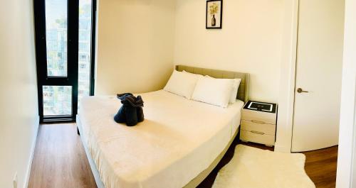 a bedroom with a bed with a black bag on it at Scenic 2BR RiverView Suite in Downtown in Calgary