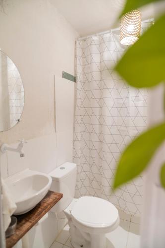 a white bathroom with a toilet and a sink at Chalé dos Ventos Preá - CE in Cruz