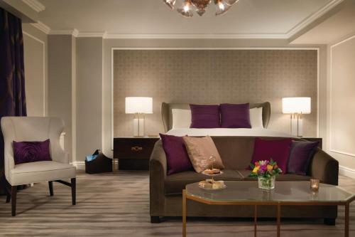 a living room with a couch and a bed at Fairmont Empress Hotel in Victoria