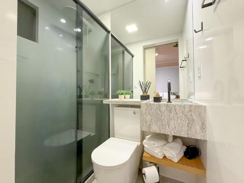 a bathroom with a toilet and a glass shower at StudioAconchego portaria 24h, elevador e garagem in Brasilia