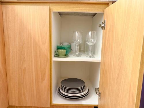 a cupboard with plates and wine glasses and plates at StudioAconchego portaria 24h, elevador e garagem in Brasilia
