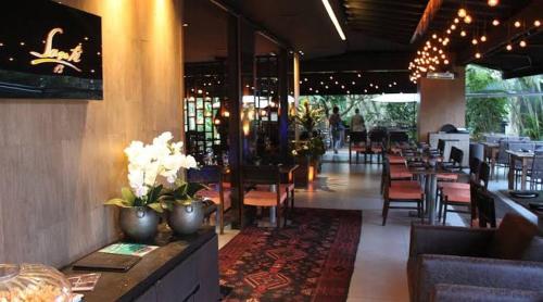 a restaurant with tables and chairs and a bar at StudioAconchego portaria 24h, elevador e garagem in Brasilia