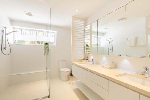 um banheiro branco com chuveiro e vaso sanitário em Mirage Resort Villa 140 with access to Sheraton Facilities em Port Douglas