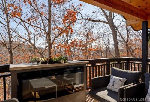 a screened porch with a fireplace on a deck at Margarita Dreams in Osage Beach