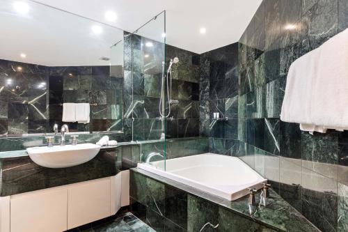 un baño con lavabo y bañera en Mirage Resort Villa 142 with access to Sheraton Facilities, en Port Douglas