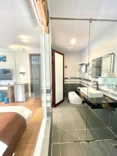 a bathroom with a glass shower and a sink at Time Villa in Tam Ðảo