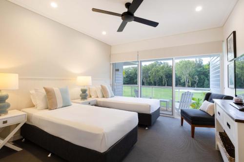 Un dormitorio con dos camas y una ventana. en Mirage Resort Villa 156 with access to Sheraton Facilities, en Port Douglas