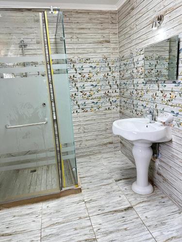 une salle de bain avec un lavabo et une douche dans l'établissement اصنع بعض الذكريات فيلا للإيجار مارينا الساحل الشمالي العلمين, à El Alamein