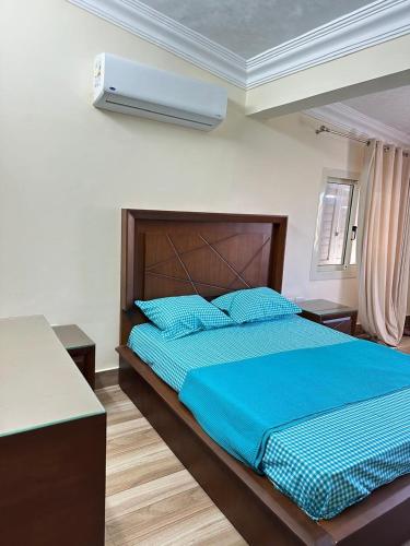 une chambre avec un grand lit avec des draps bleus dans l'établissement اصنع بعض الذكريات فيلا للإيجار مارينا الساحل الشمالي العلمين, à El Alamein