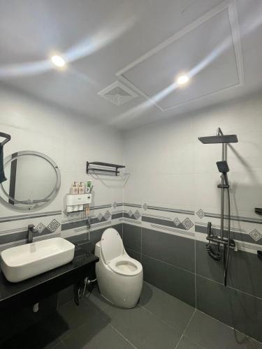 a bathroom with a toilet and a sink and a mirror at Time Villa in Tam Ðảo