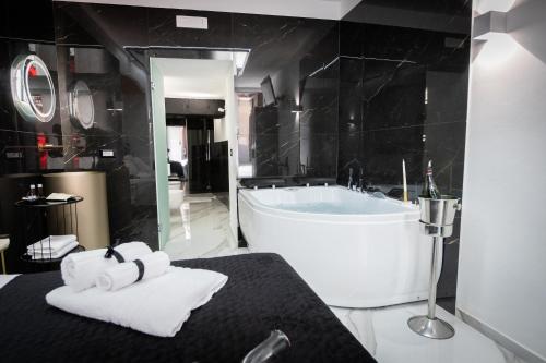 a bathroom with a large tub and towels on a bed at Palermo Luxury Rooms White in Palermo