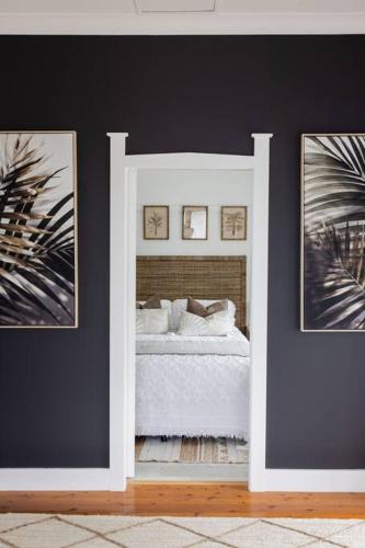 a bedroom with a bed and two pictures on the wall at Sea Cliff Sands Gerroa in Gerroa