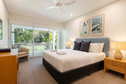 a bedroom with a large bed and a living room at Mirage Resort Villa 158 with access to Sheraton Facilities in Port Douglas