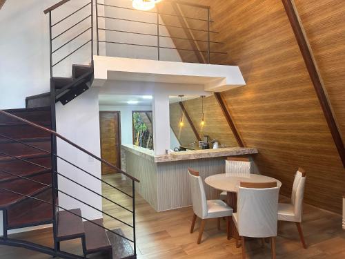 a dining room with a table and a staircase at Morada das colinas in Garanhuns