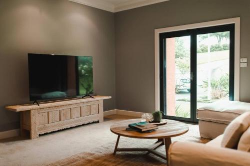 a living room with a large flat screen tv at Excelsa- sweeping valley in Rose Valley